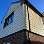fiber cement siding, commonly referred to as Hardie Plank cladding, installed on the upper level of a house.