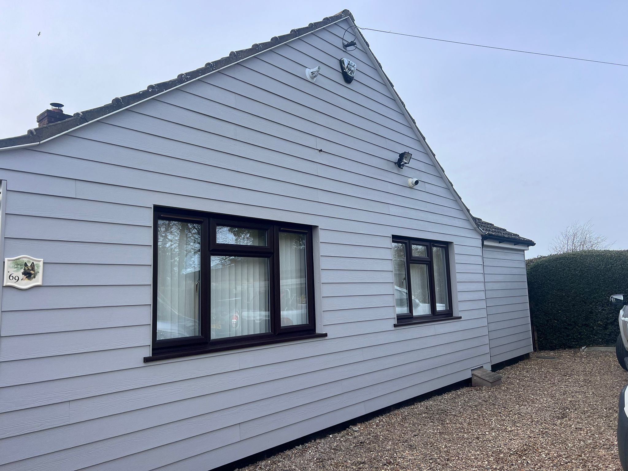 Full transformation of a Melbourn home featuring light grey fibre cement cladding and new fascia boards.
