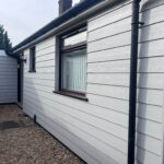 Completed grey Hardie Plank cladding with professional trim and mahogany window sill extensions